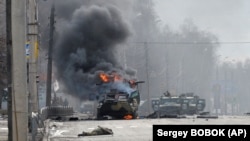 Российский бронетранспортер горит во время боя с бойцами Вооруженных сил Украины в окрестностях Харькова, Украина, 27 февраля 2022 года